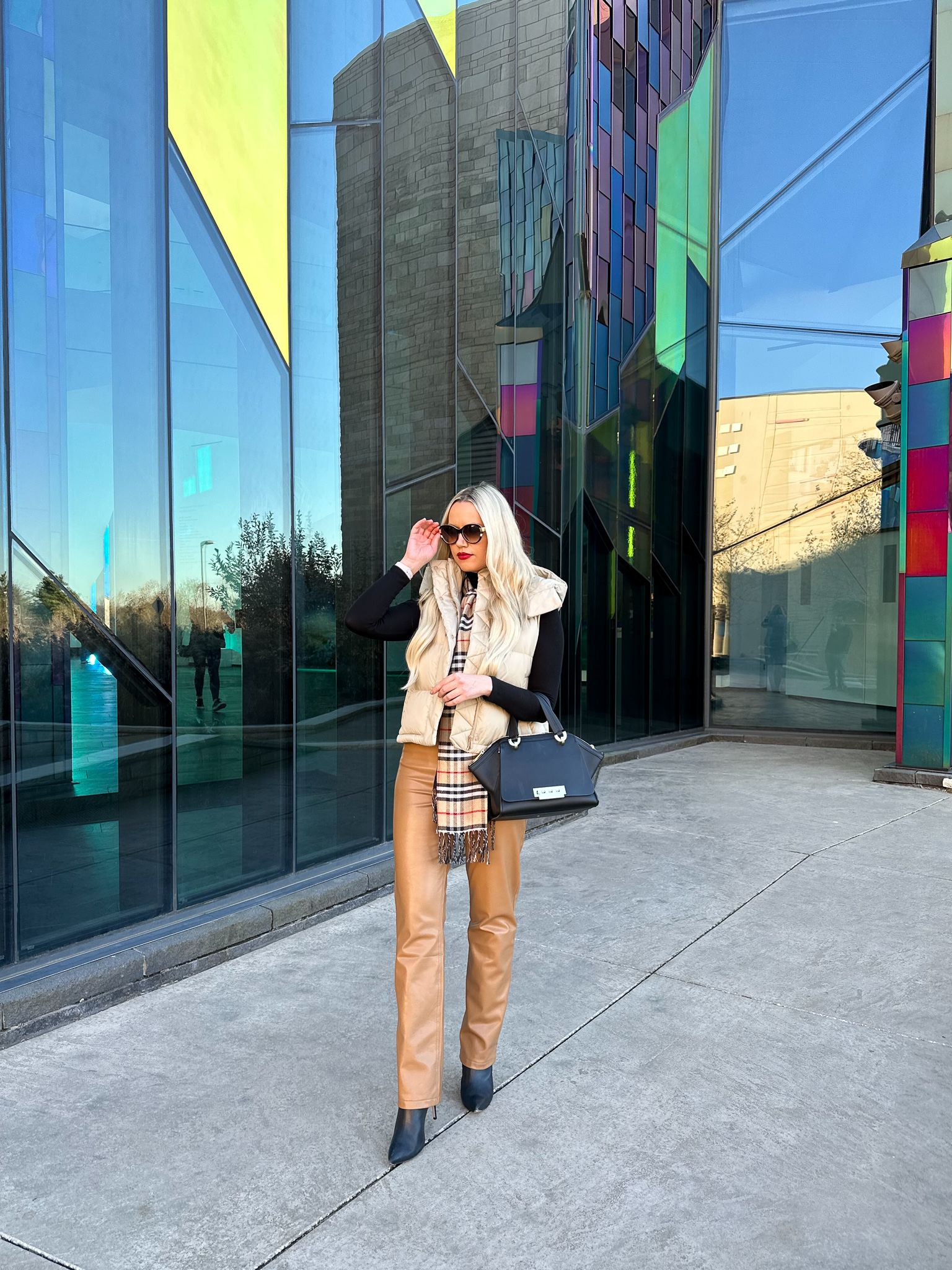 Shay styles a beige puffer vest and brown faux leather pants