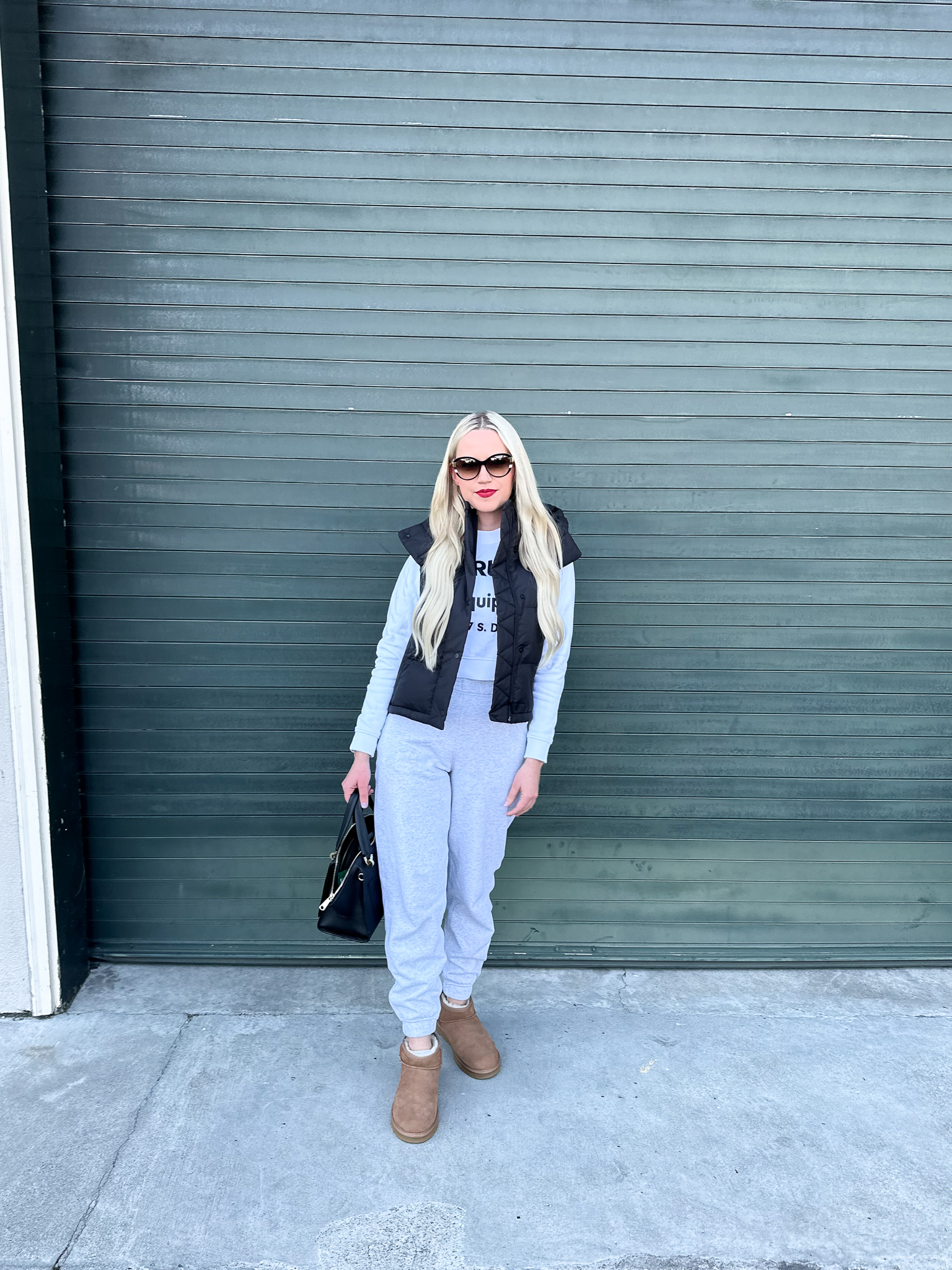 Black puffer vest and grey sweatpants