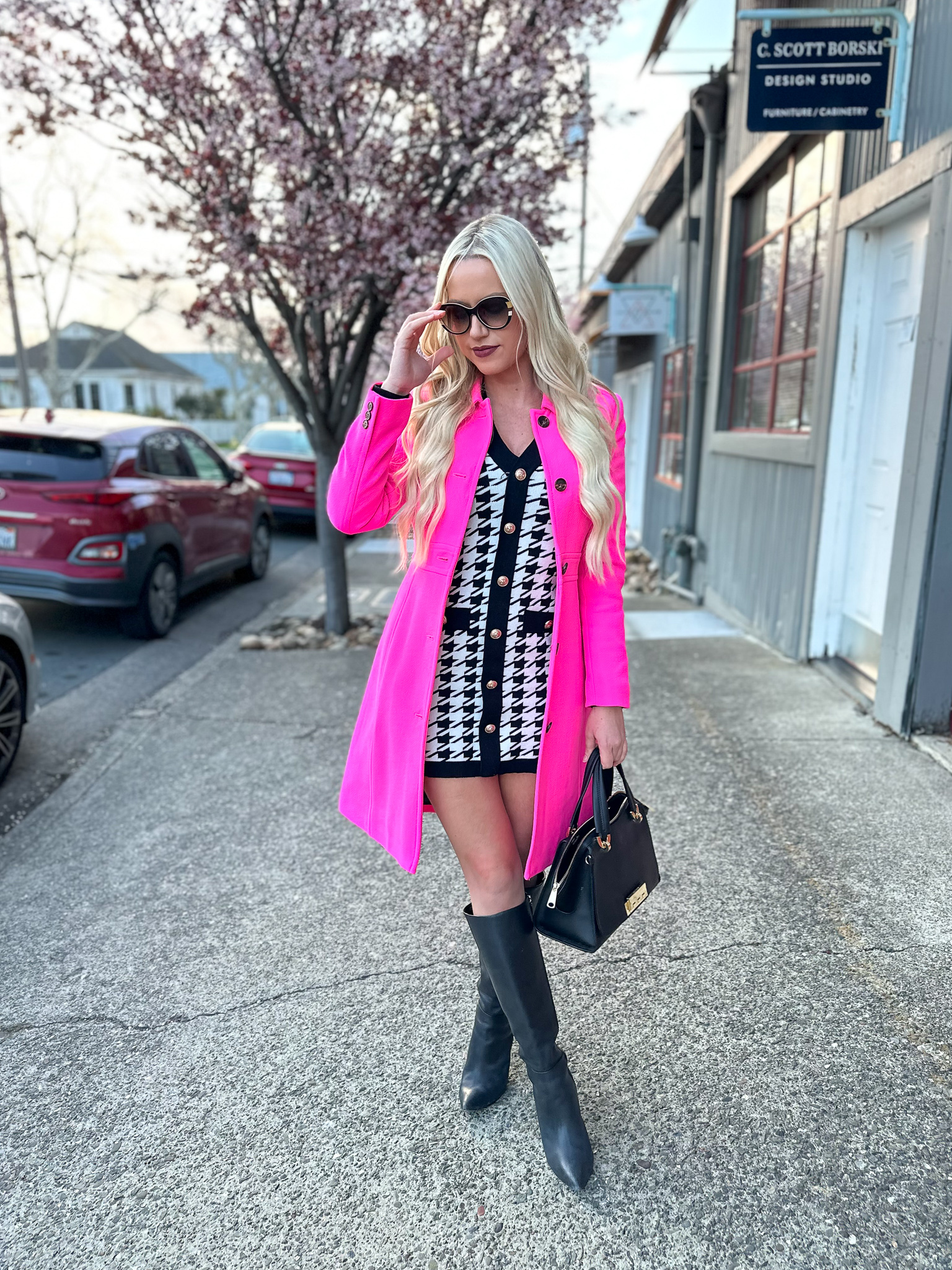 Shay styles a black and white houndstooth dress with a bright pink coat
